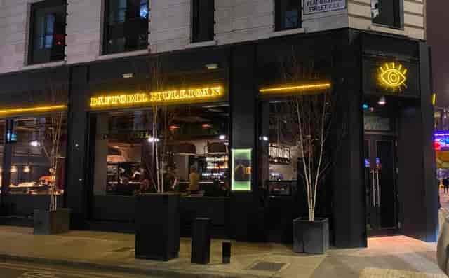 Modern Daffodil Mulligan restaurant exterior with neon signage for private events and receptions.