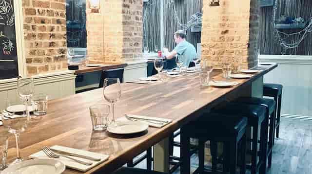 Communal high-top seafood bar at La Petite Poissonnerie for networking and team social events.
