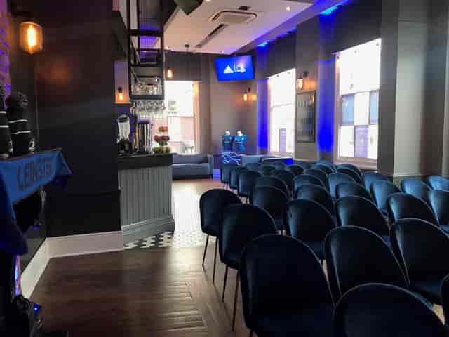 Modern event space with plush chairs, ideal for meetings and presentations at The Thirsty Scholar.