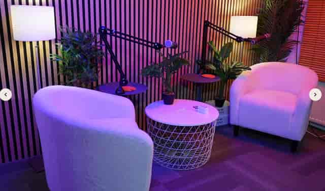 Modern podcast studio with cozy chairs and adjustable microphones for creative events.
