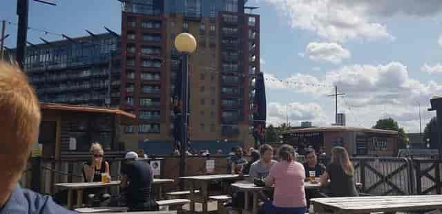Outdoor post-conference mixer with communal seating and pizza at The Oiler Bar waterfront.