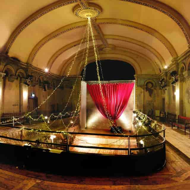 Elegant ballroom with red curtains for intimate events and performances in Acantilados.