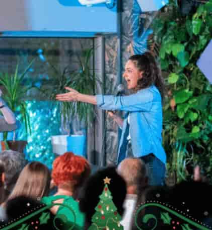 Speaker at The 99 Club with biophilic plant wall for corporate events and wellness conferences.