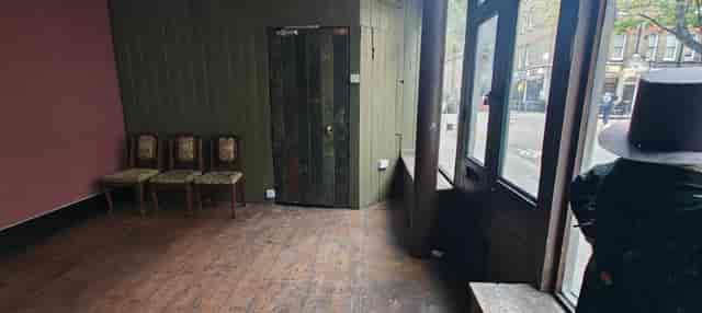 Ground floor venue space at 41 Whitfield Street with dated seating for event hire and renovation.