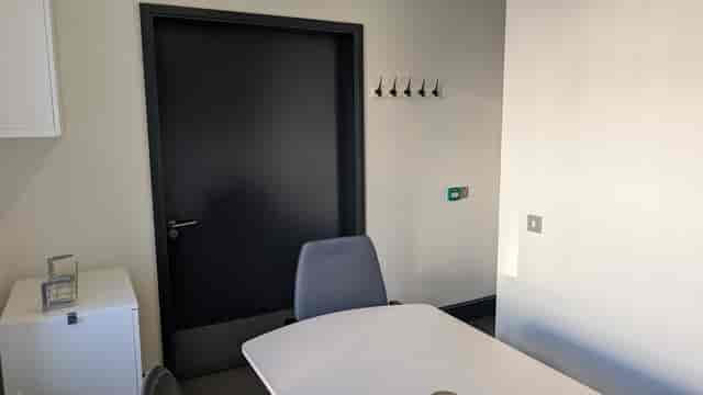 Office space with sleek table and ergonomic chairs, ideal for meetings and gatherings.