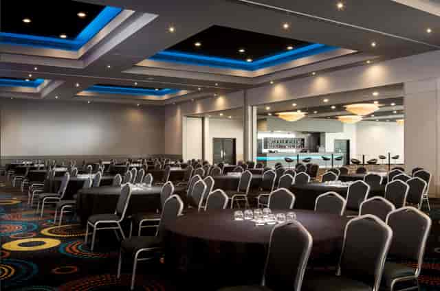 Modern ballroom with blue LED lighting for corporate dinners and gala events.