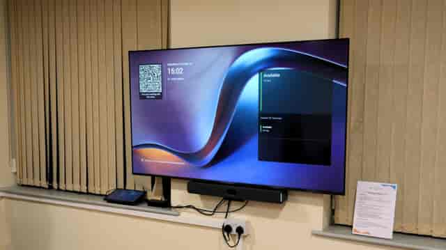 Modern Red Room meeting space with professional AV setup for corporate events and workshops.
