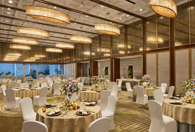 Elegant event space at Four Seasons Hotel Mumbai with floral centerpieces; ideal for weddings, galas.