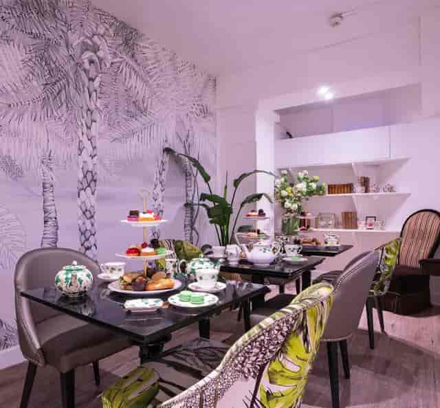 Elegant afternoon tea setup at Brigit's Bakery Covent Garden with fine china and tropical decor.