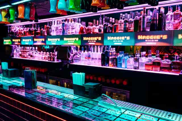 Vibrant bar setup with colorful bottles for events and networking at Maggie's venue.