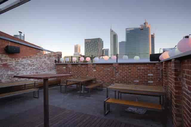 Rooftop terrace with string lights, ideal for corporate happy hours and networking mixer events.