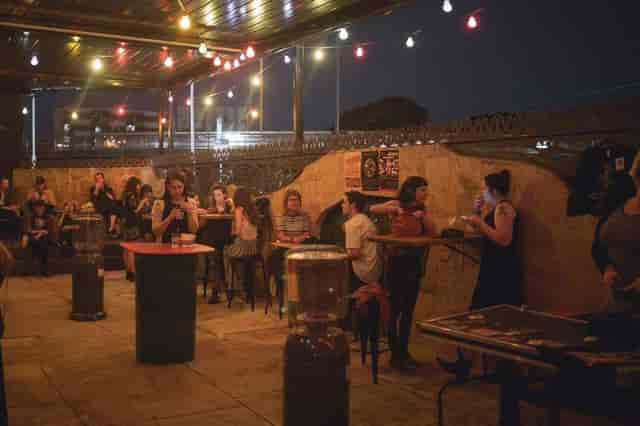 Outdoor networking reception at Badlands Bar with bistro tables and string lighting.