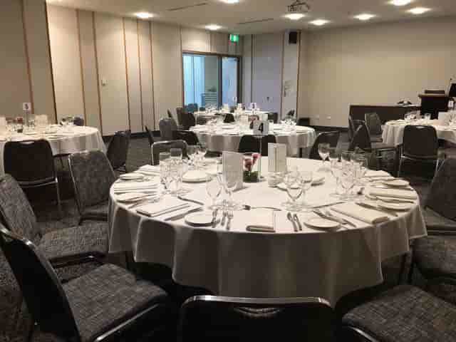 Banquet-style seminar room with round tables for corporate luncheons and gala dinner events.