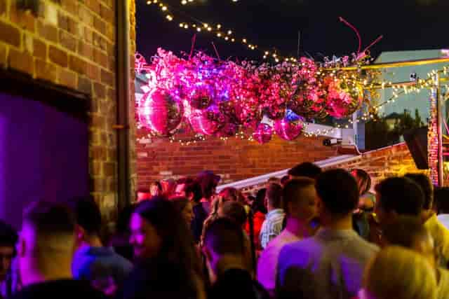 Rooftop terrace with floral disco ball decor for evening reception and networking events.