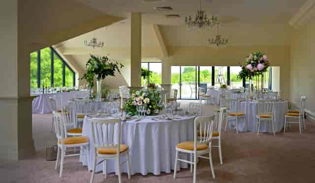 Royal Suite wedding setup at Cambridge Country Club with floral centerpieces and gilded chairs.