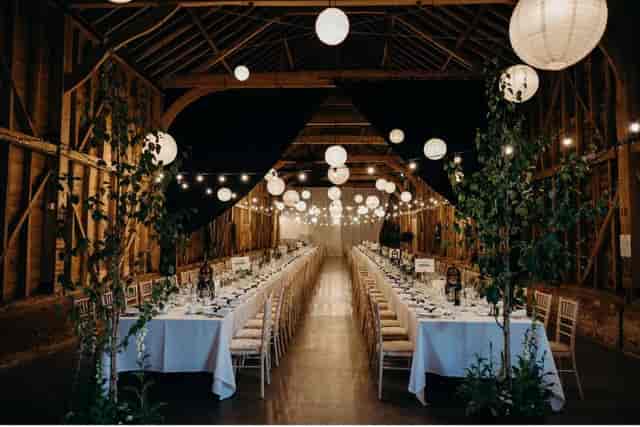 The Long Barn at Childerley Hall, rustic long-table wedding venue with ambient lighting.