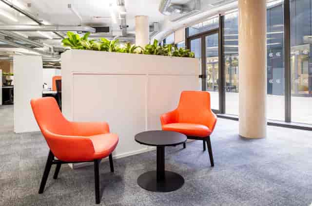 Modern event space with vibrant orange chairs for networking and meetings.