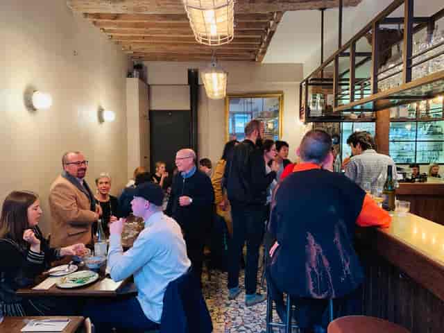 Vibrant networking event at Le Grand Bain with communal seating promoting conversation.
