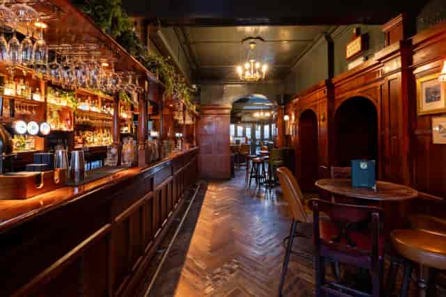 Stylish Balham Bowls Club lounge with wooden accents, perfect for networking events and gatherings.