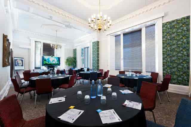 Exhibition Hall cabaret-style meeting room with high ceilings for corporate workshops and events.