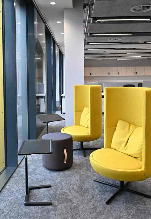 Modern seating area with yellow chairs for collaborative meetings at PHTA Accelerator.