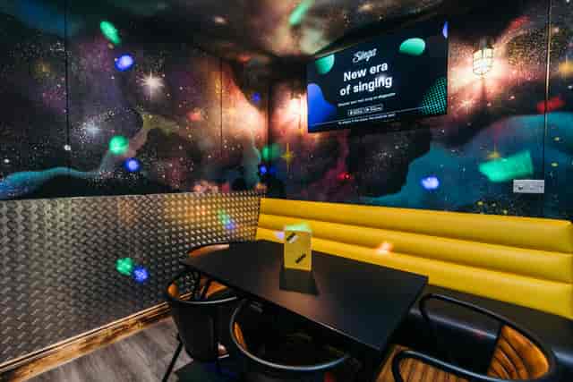 Vibrant karaoke room with galaxy mural, ideal for corporate events in Belfast.