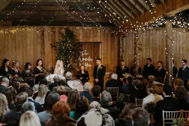 Beautiful wedding venue at The Byre, featuring rustic wood backdrop and fairy lights.