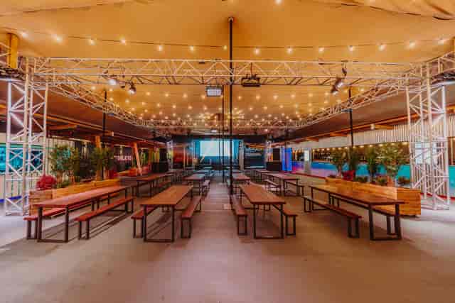Full venue hire at Freight Brixton featuring industrial truss and communal bench seating for events.