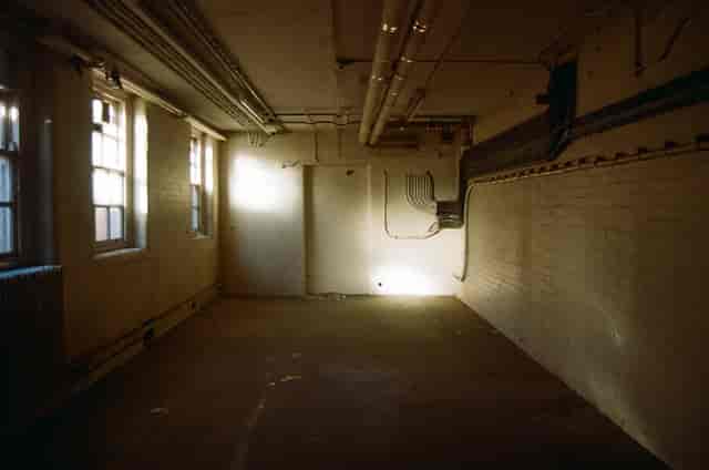 Empty, well-lit event venue with exposed pipes; perfect for creative setups and minimalistic themes.