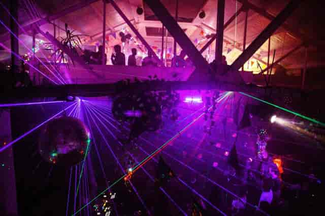 Vibrant event space at The Warehouse with colorful lasers; perfect for parties.