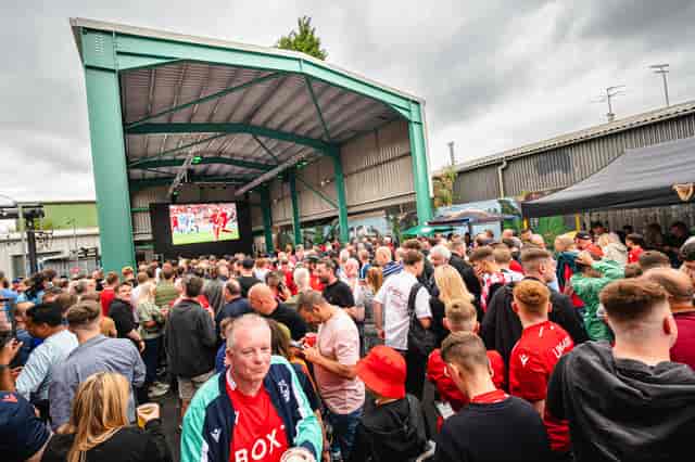 Vibrant Big Shed venue with large screen for community events and sports screenings.