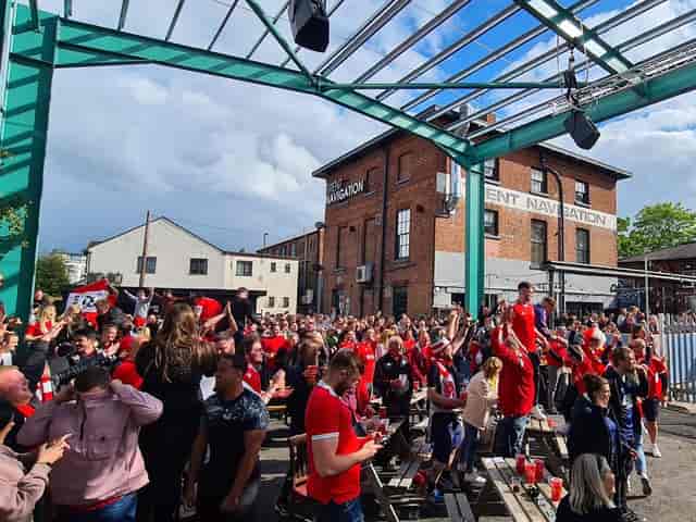 Outdoor gathering at Ye Olde Trip to Jerusalem, vibrant red attire, sports celebrations, festivals.