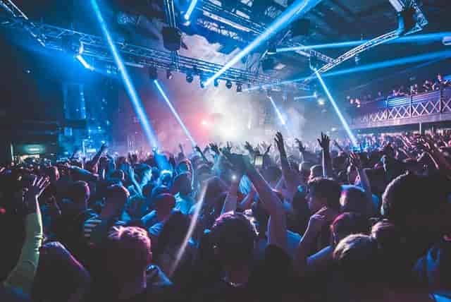 Vibrant crowd at Stealth venue with laser lights for energetic concert atmosphere.