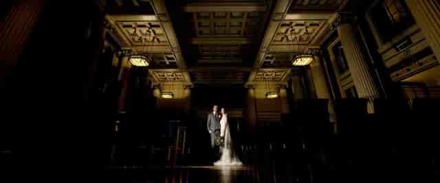 Elegant wedding ceremony at Nottingham Playhouse with ornate architecture and warm lighting.