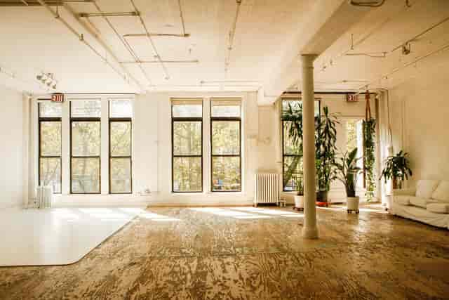 Spacious meeting room with natural light and greenery, ideal for workshops and events.