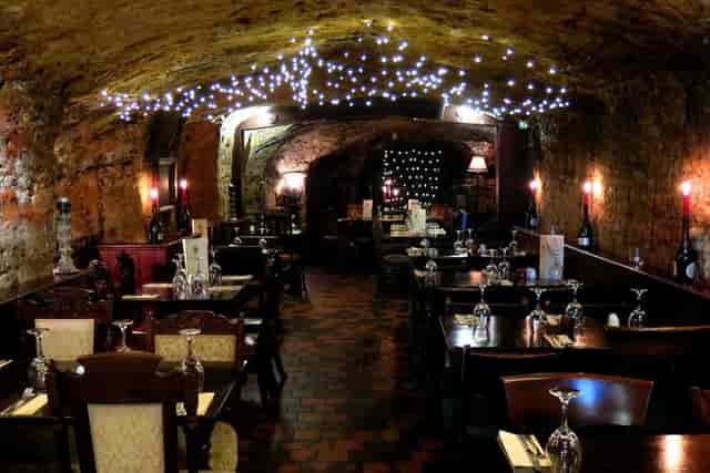 Charming dining space at Bell Inn Cave Cellars with rustic stone walls, ideal for events.