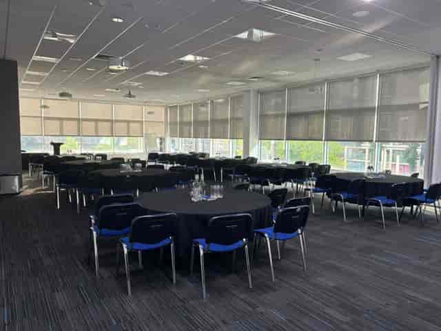 Spacious T&D Café meeting room for workshops, featuring round tables and natural light.