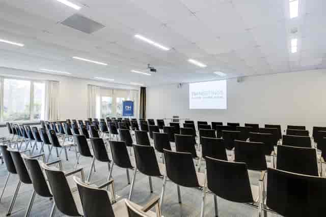 Modern conference room with black chairs for meetings at NH Eindhoven Hotel.