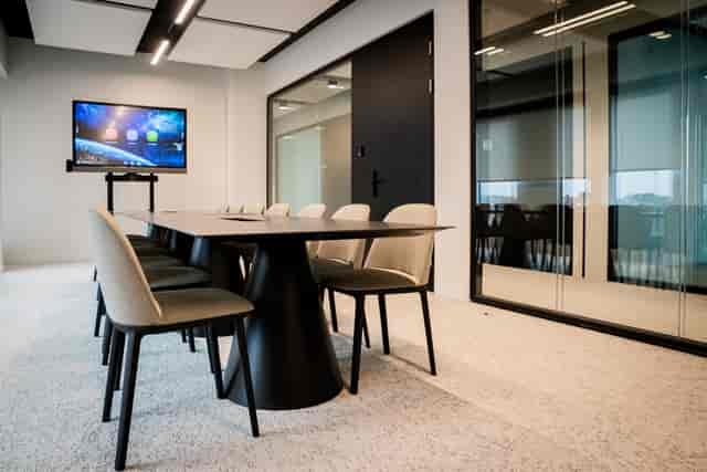 Modern glass-walled boardroom for executive meetings and hybrid corporate strategy sessions.
