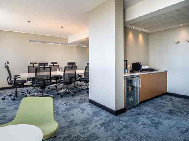 Boardroom-style meeting space at Crowne Plaza Antwerp with integrated refreshment station.