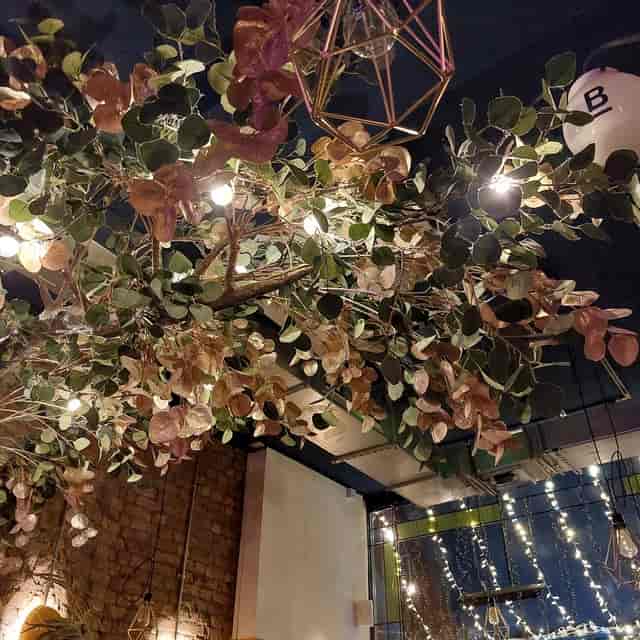 Botanical cocktail bar interior, lush overhead installation