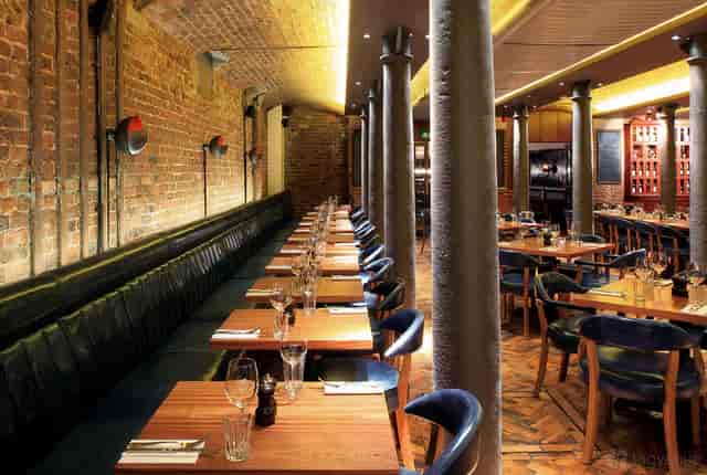 Industrial-chic private dining room with exposed brick for corporate dinners and networking events.