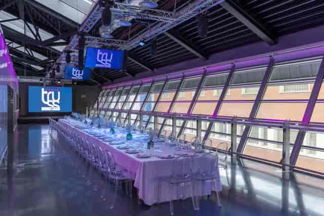 Corporate dinner event at Sala Leds Madrid featuring sleek banquet seating and AV truss lighting.