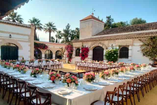 U-shaped banquet setup in historic Sevilla courtyard for elegant corporate or social dining events.
