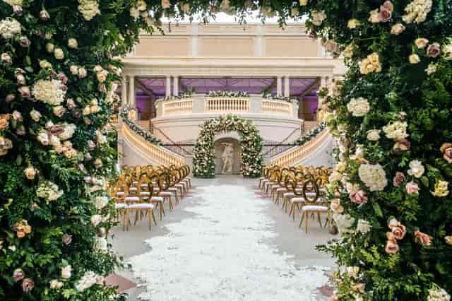 Luxury wedding ceremony in Main Event Space with floral aisle and gold seating.