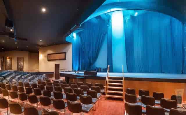 Railhead theater stage with blue uplighting for corporate events and keynote presentations.