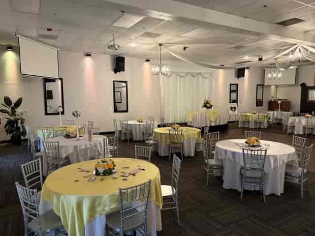 Main Banquet Hall with yellow table linens and silver chairs for wedding or corporate events.