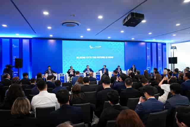 ALATAU Hall Korme Center: Blue corporate plenary stage with packed audience at B2B event.