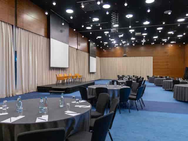 Plenary room at Rooms Hotel Tbilisi with stage and screens for corporate conferences and events.