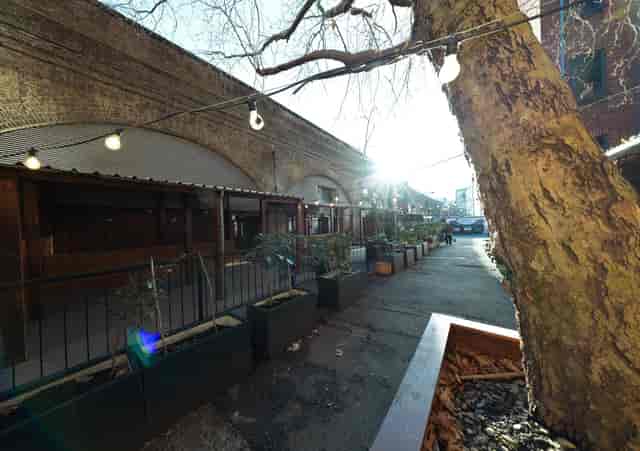 Industrial-chic garden venue with festoon lighting for pop-up markets and networking events.